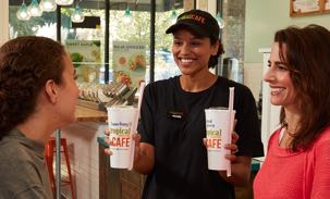 Employee handing guests smoothies