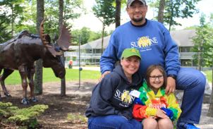family in front of a moose statue